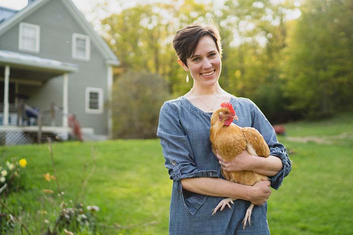 Liz personal finance specialist holding a chicken from her farm